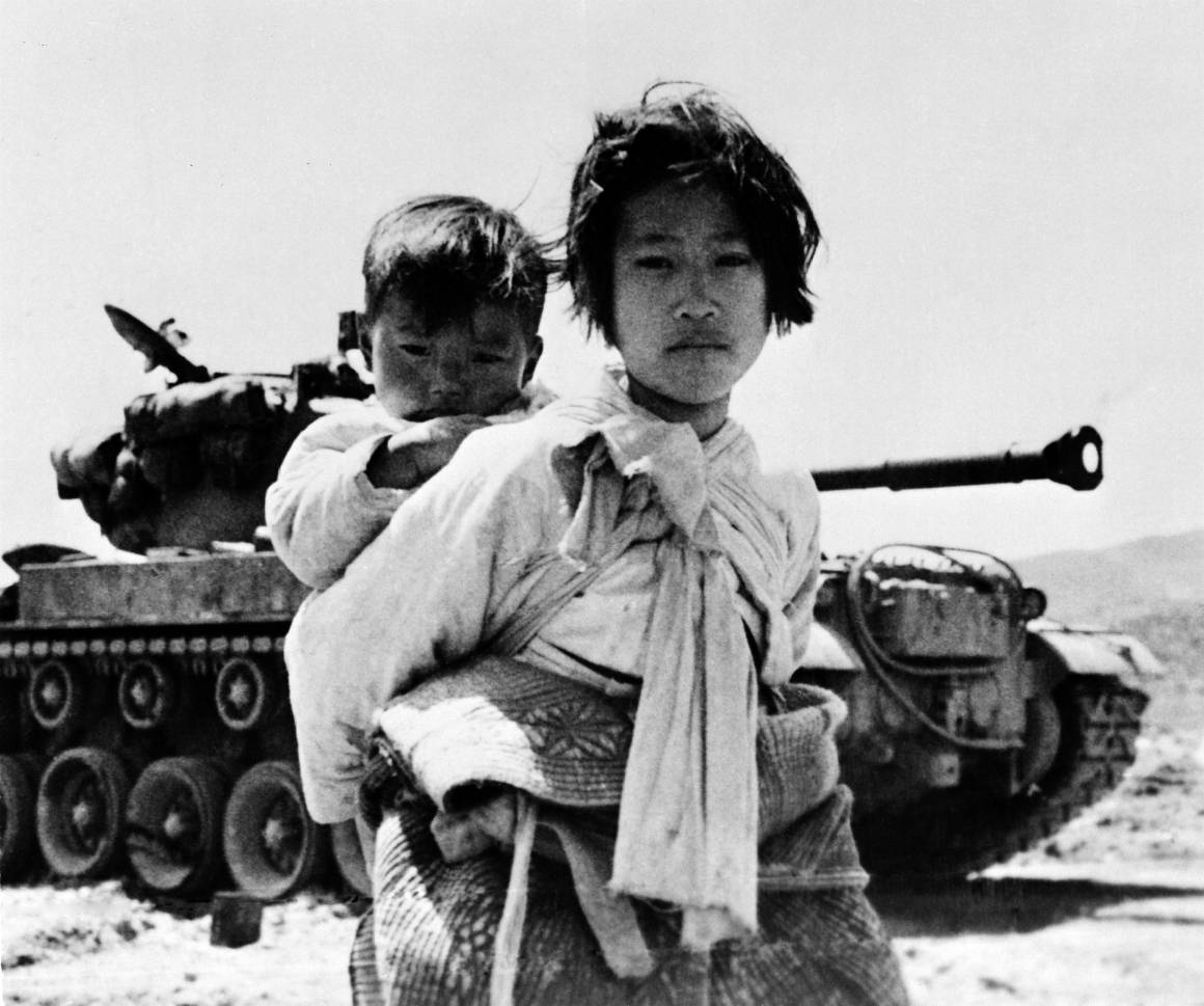 En ni år gammel jente bærer på sin lillebror. Bildet av dette foreldreløse søskenparet på flukt ble tatt under Koreakrigen, 9. juni 1951. Foto: UN Photo/United States Navy.